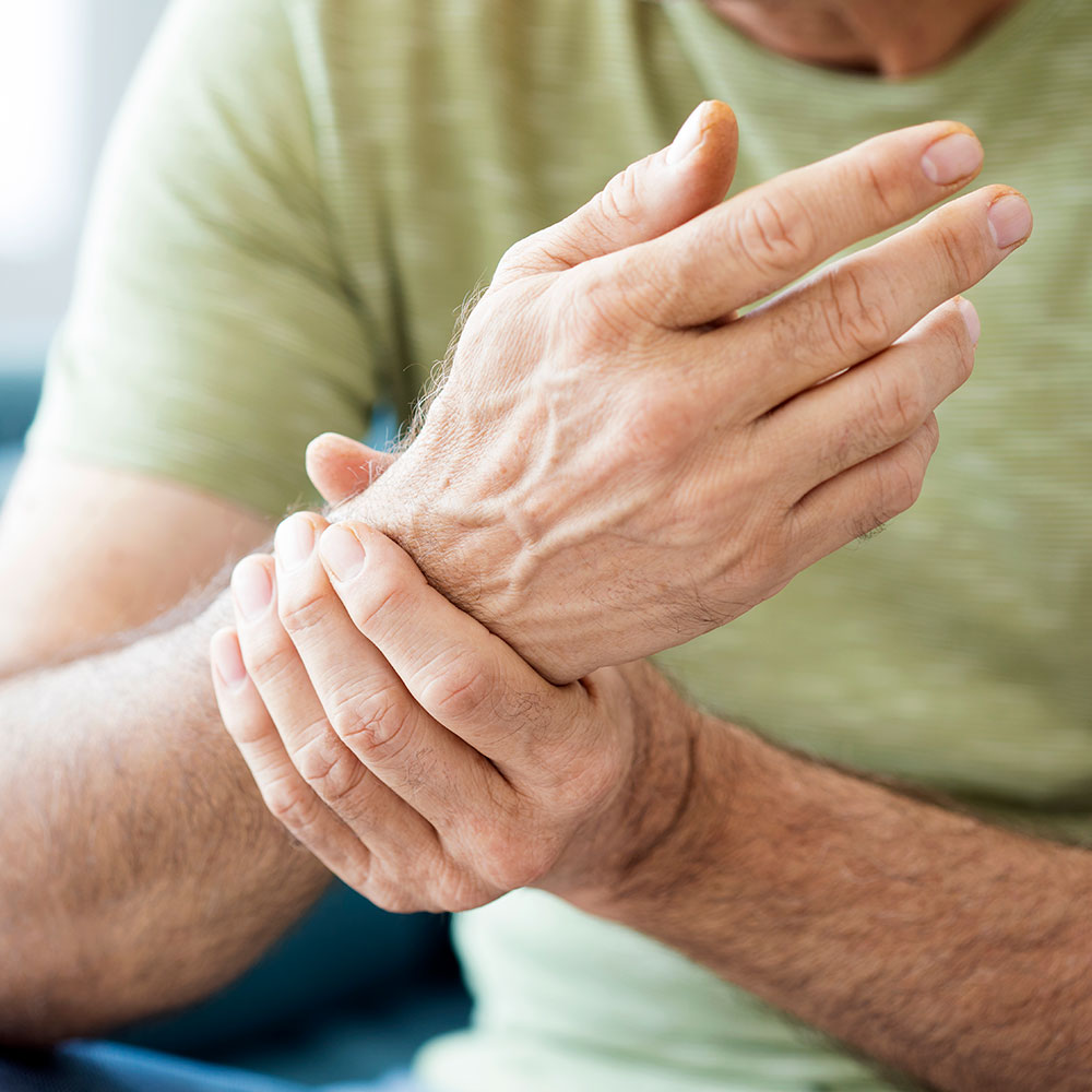 Man holding wrist with other hand